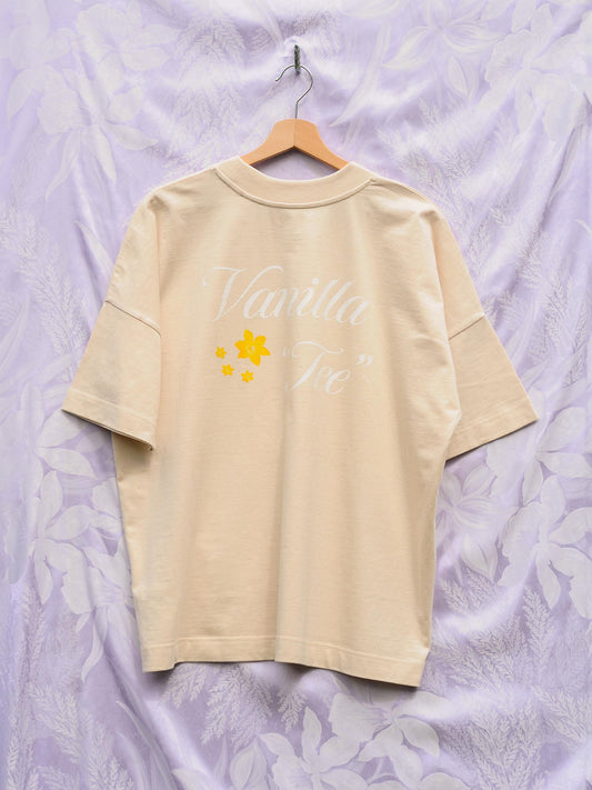 a oversized vanilla colored t-shirt with a vanilla tee print and four golden flowers on the back.