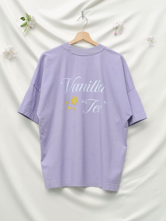 A oversized lilac t-shirt with a vanilla tee print and four golden flowers.