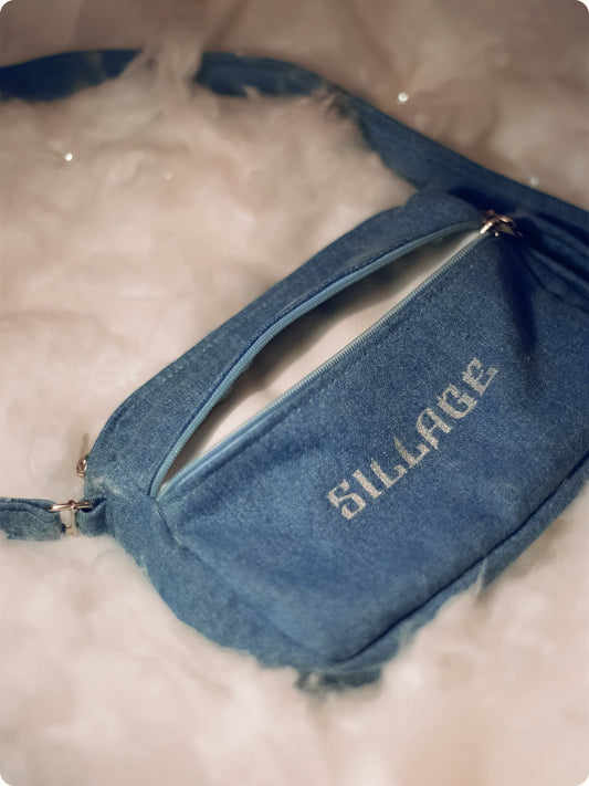 The Sillage Denim Shoulder Bag is an essential for everyday life. Pack your keys, wallet, phone or other things. The Bag is made from Denim with a silver/gold satin lining on the inside. 
