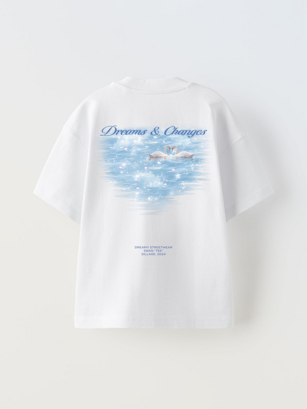 a oversized white t-shirt with a dreamy swan design. Shiny light blue water with cherry blossom leaves and two swans almost kissing.