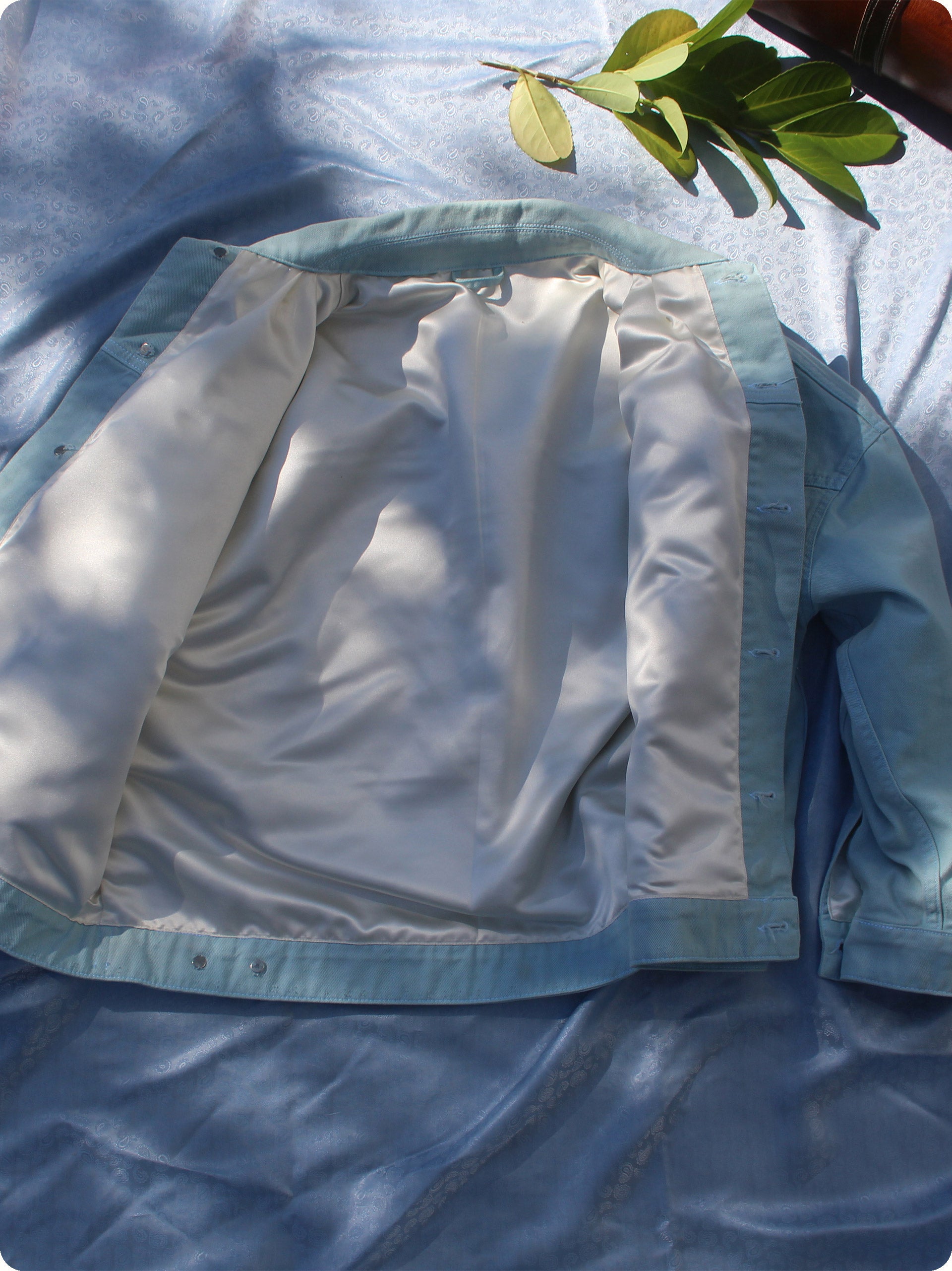 The Rose N Tears Denim Jacket has a silver/gold satin lining on the inside which shimmers in the sun