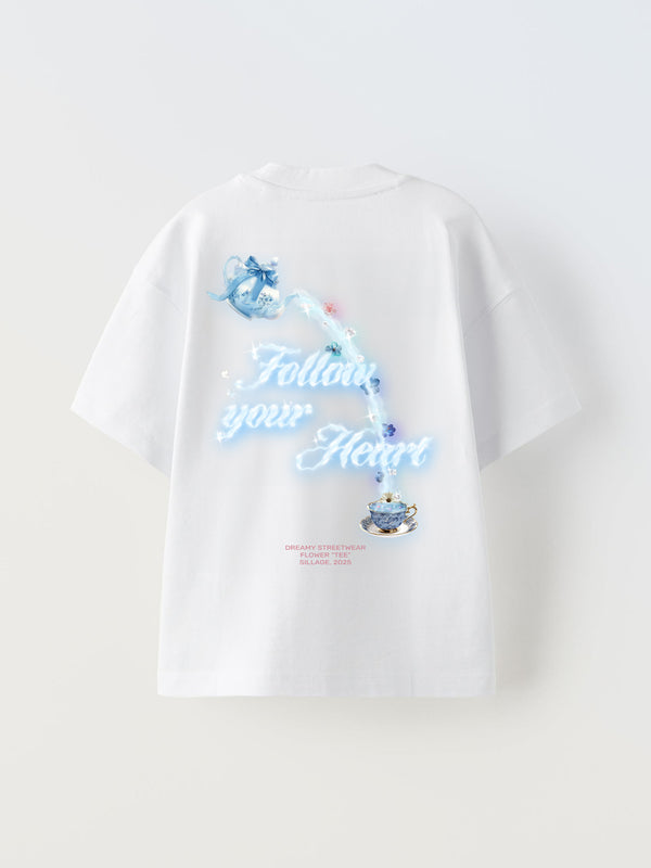 White oversized t-shirt with a printed floral and tea cup design saying 'Follow your Heart' on the back.