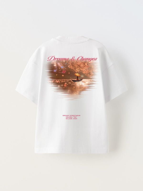White t-shirt with a dreamy gold design featuring maple leaves, printed text 'Dreams & Changes', and a signature at the bottom.